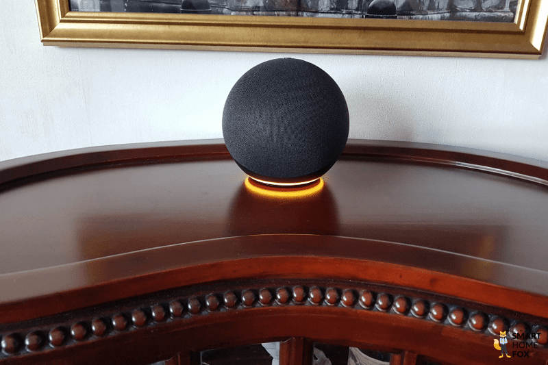 An Alexa Echo Dot stands on the table and the ring colour is yellow.